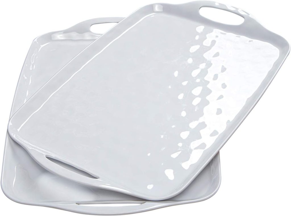 Two white rectangular serving trays with built-in handles are stacked slightly askew on top of each other. The trays have a glossy, textured surface, making them perfect for effortlessly carrying food and drinks at your outdoor grilling station.