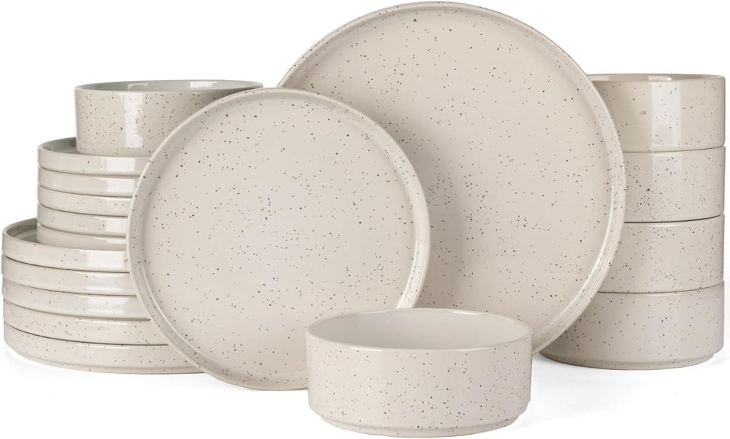 A set of beige, speckled stoneware dishes—including dinner plates, salad plates, and bowls—arranged in neat stacks, perfect for upgrading your tableware on Amazon Prime Day.