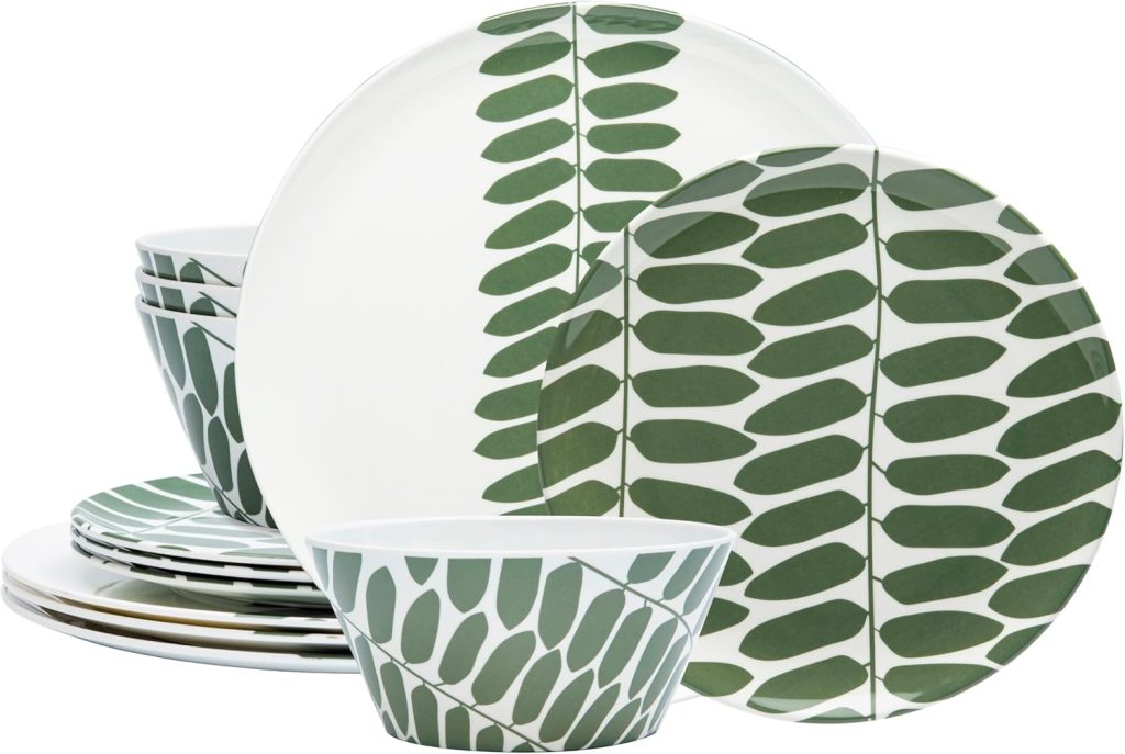 A set of ceramic dinnerware, including bowls and plates, with a green leaf pattern on a white background arranged side by side—perfect for serving your favorite dishes at an outdoor grilling station.