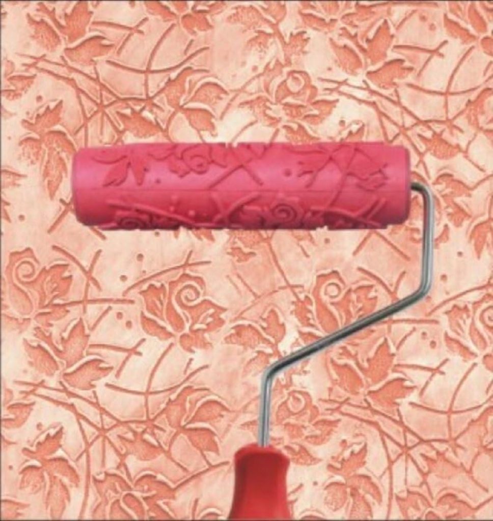 A patterned paint roller with a floral design is shown, rolling over a wall to create a textured floral pattern on a peach-colored background—perfect for adding charm to Creative Crafts projects.