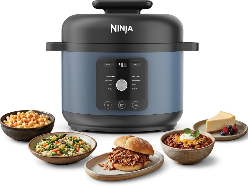 A Ninja pressure cooker with digital controls, surrounded by five dishes—chickpeas, salad, a sandwich, chili, and cheesecake with berries—makes the perfect kitchen upgrade for Amazon Prime Day.