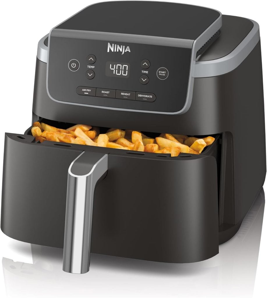 A black Ninja air fryer with its basket partially open, filled with cooked French fries, is featured as part of The Best Amazon Prime Day 2025 Deals - Day Four. The display shows a timer set to 4:00.