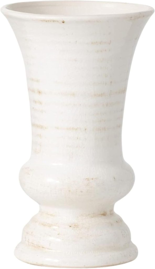 A tall, white ceramic vase with a flared rim and a rounded base, featuring subtle textured lines and a slightly distressed finish.