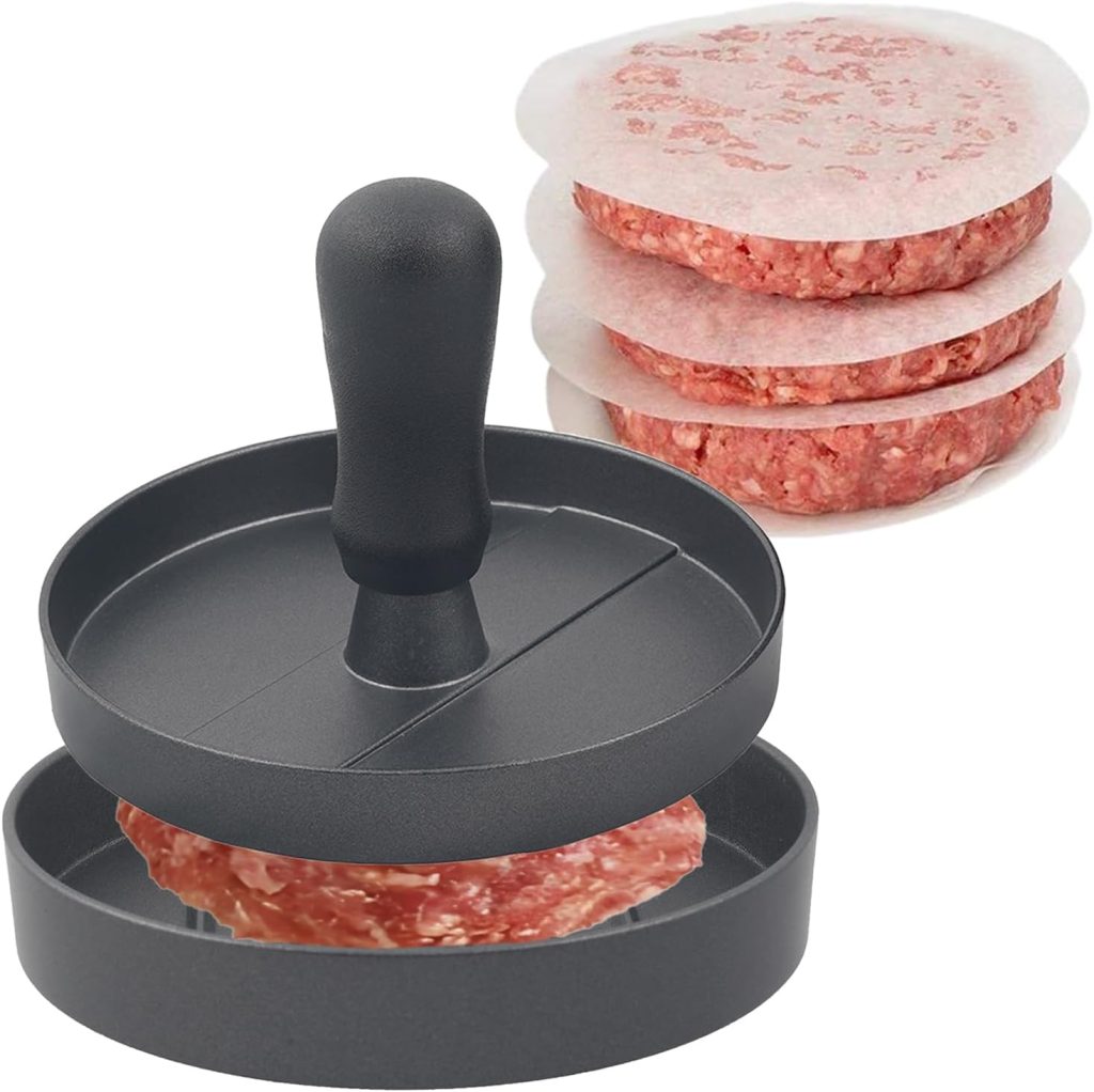 A burger press shaping a raw beef patty, with a stack of three formed patties separated by wax paper in the background.