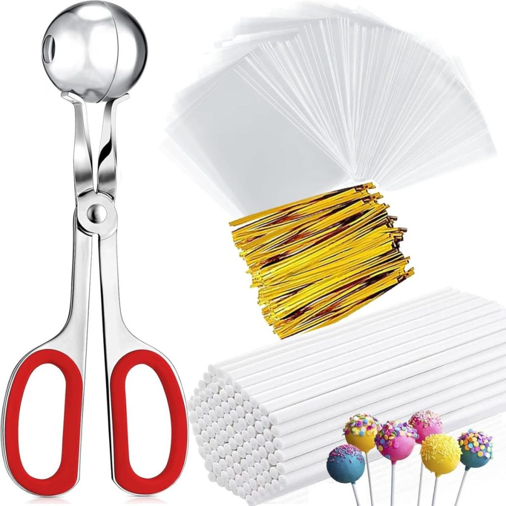 A cake pop making kit with a metal scoop, white sticks, clear plastic bags, gold twist ties, and decorated cake pops.