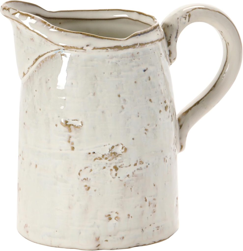 A white, rustic handmade clay ceramic pitcher with a handle and spout, featuring an uneven surface and distressed finish.