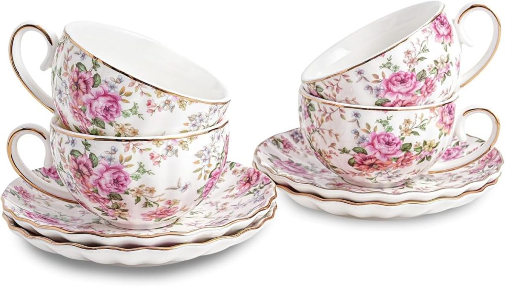Four porcelain teacups with floral patterns, each stacked on matching saucers with gold trim.
