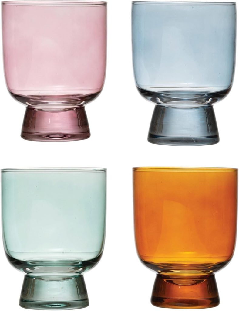 Four short, wide drinking glasses in pastel pink, blue, green, and amber, each with a thick, slightly flared base, are displayed against a white background—perfect for serving your favorite creamsicle recipes.