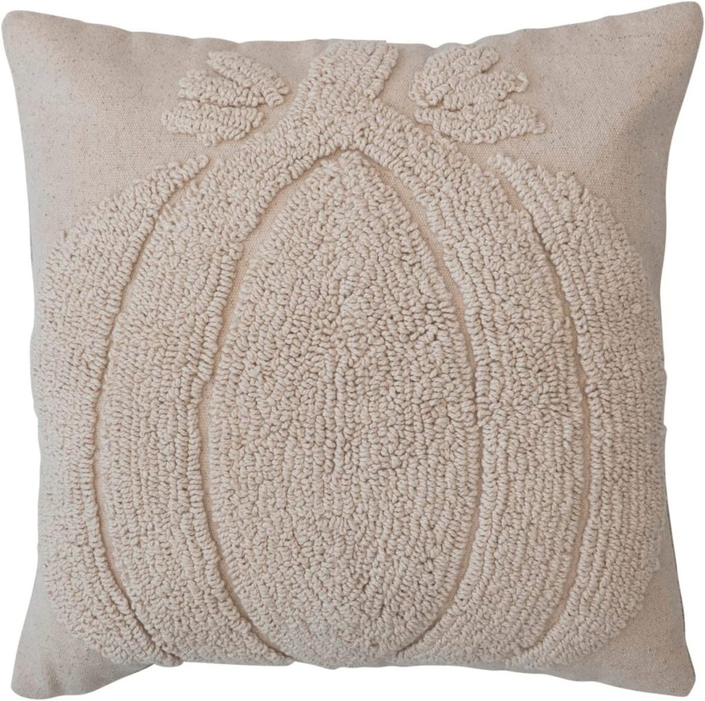 Square beige pillow with a textured, raised pattern depicting a pumpkin design on the front.