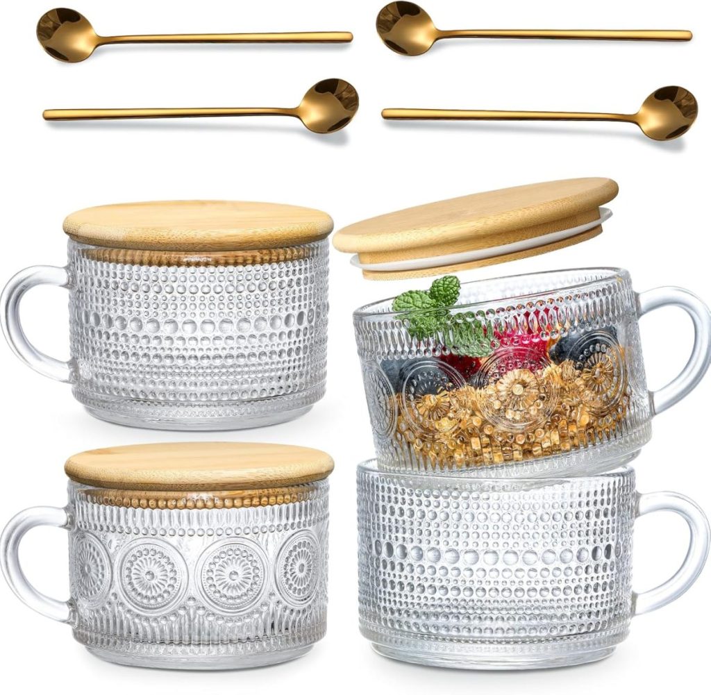 Four clear glass mugs with textured patterns and wooden lids, stacked and displayed with four gold-colored metal spoons above them.