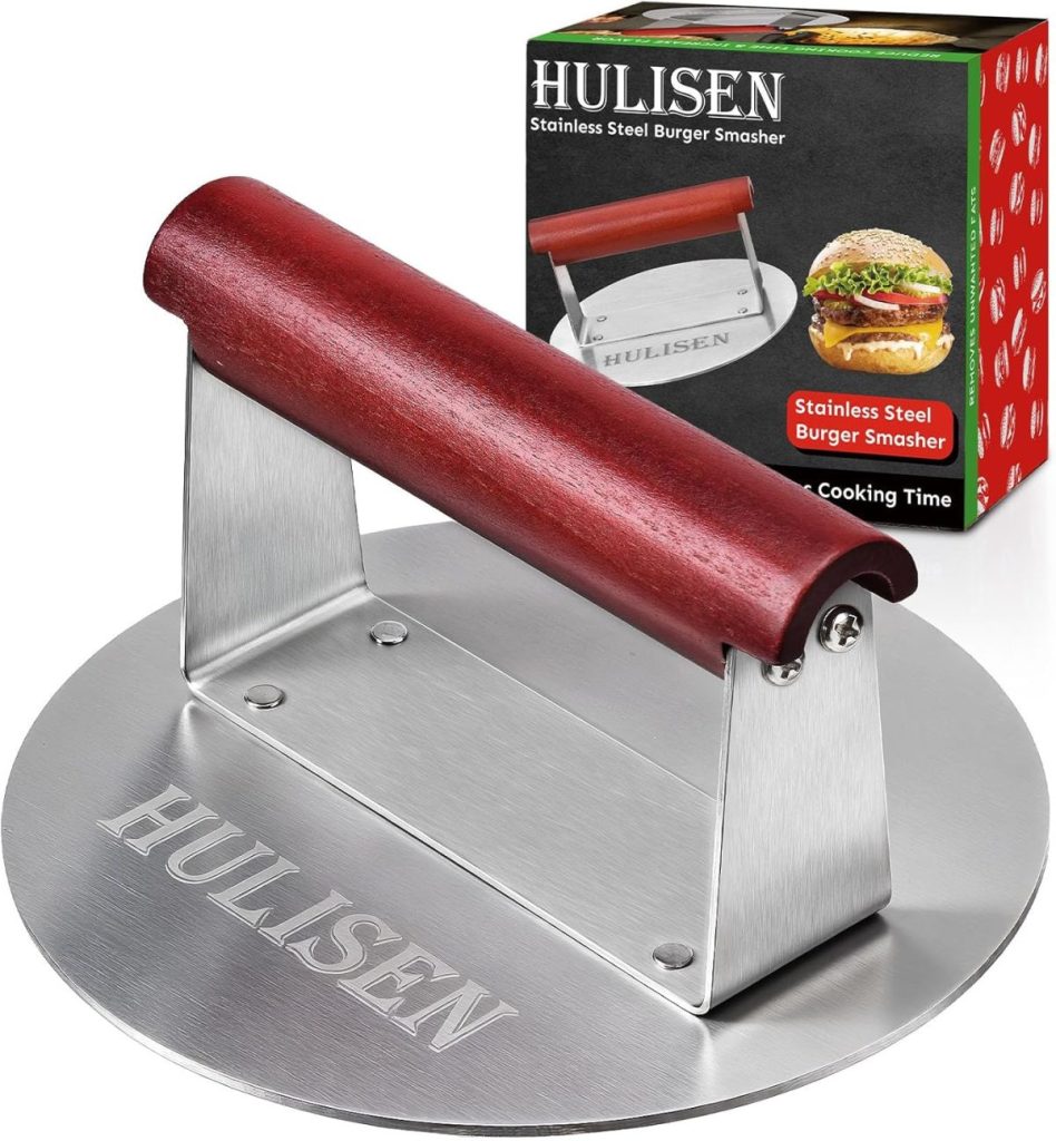 A stainless steel burger smasher with a red wooden handle is shown next to its packaging, which displays an image of a burger and product branding.
