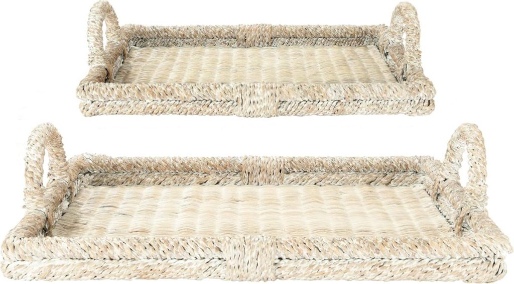 Two rectangular woven wicker trays with handles on each side, one tray stacked slightly above and behind the other, both in a natural beige color.
