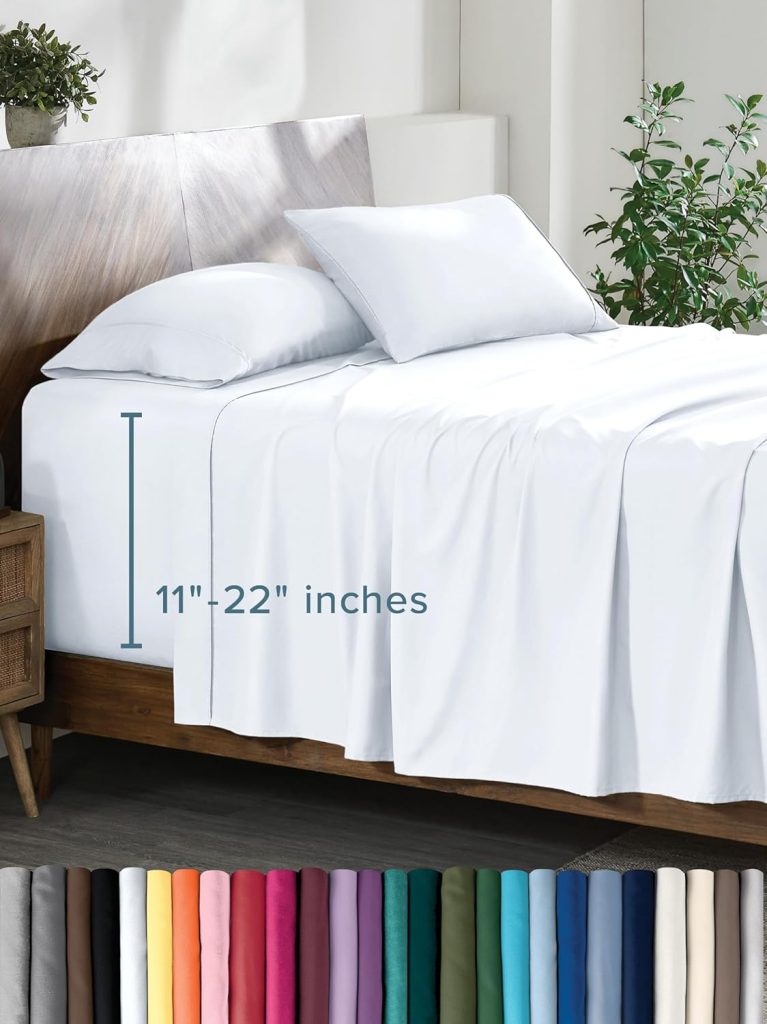 A neatly made bed with white sheets and two pillows, labeled with a fitted depth of 11"-22". A row of sheets in various colors is displayed at the bottom.