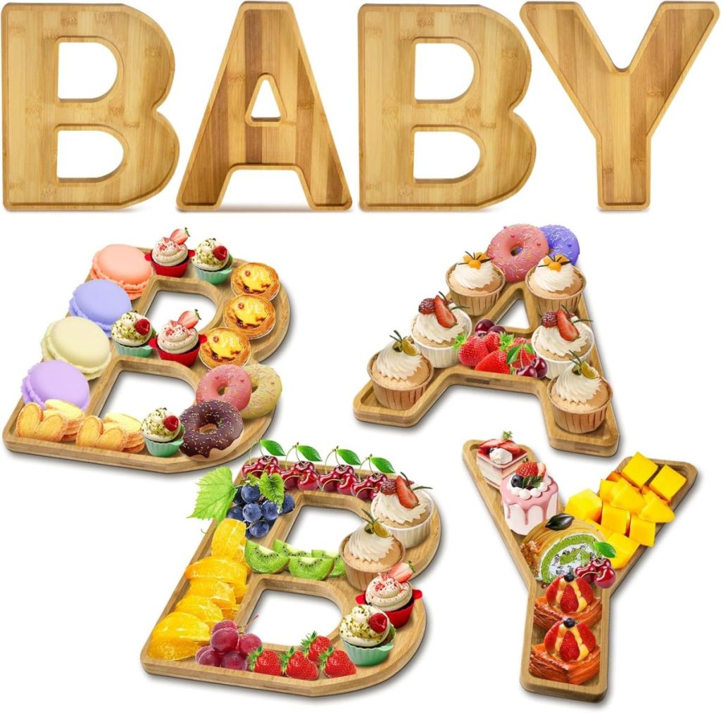 Wooden trays shaped like the letters B, A, B, and Y are filled with assorted desserts, fruits, and sweets, spelling out the word "BABY.
