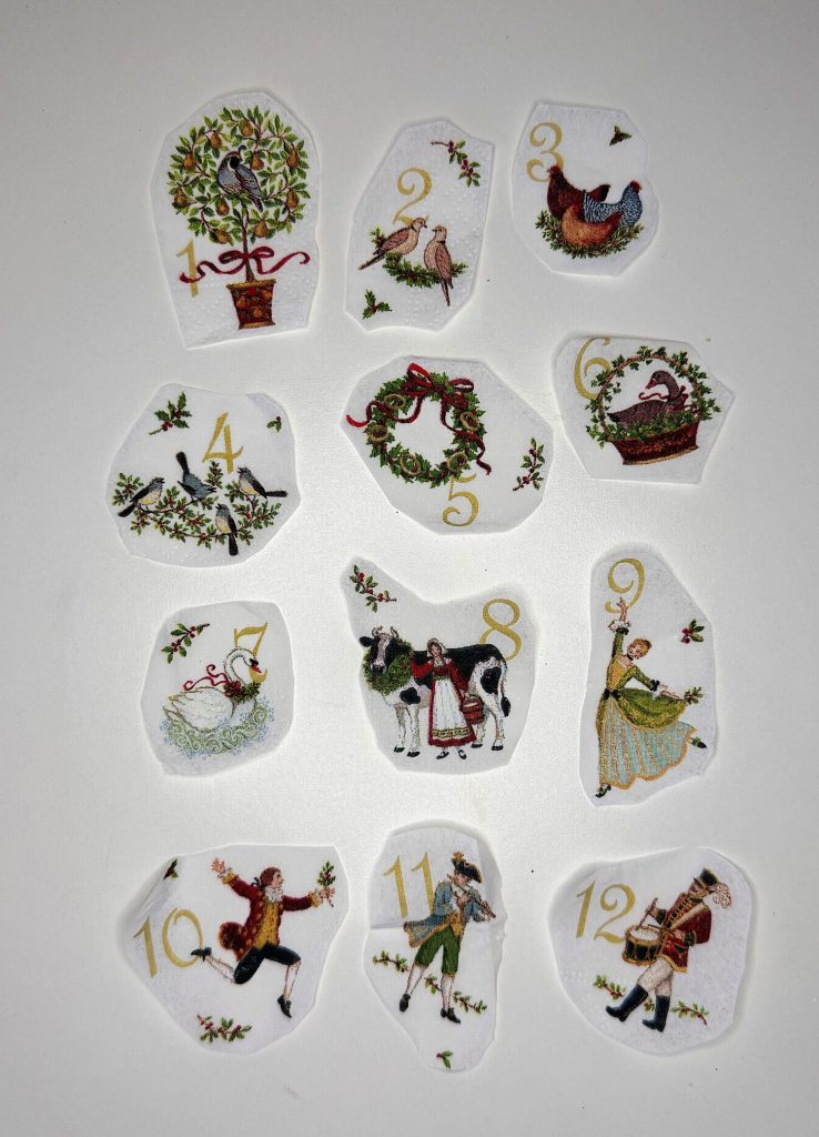 Twelve illustrated pieces, each with a number from 1 to 12 and corresponding images from the "Twelve Days of Christmas" song, arranged on a white surface.
