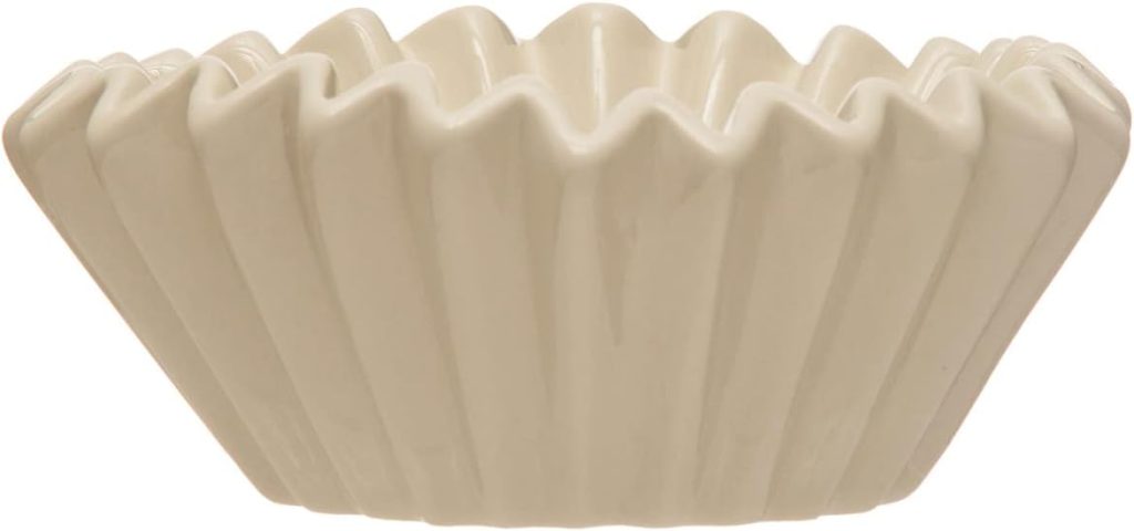 A ceramic bowl shaped like a coffee filter, with a wavy, ridged edge and a matte off-white finish.