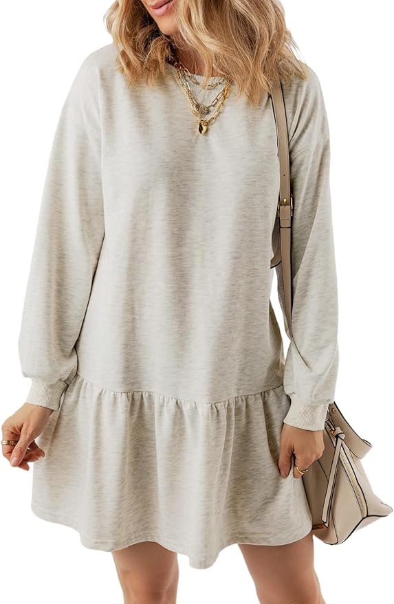 Woman wearing a light beige long-sleeve, loose-fit dress with a ruffled hem, layered necklaces, and carrying a matching beige handbag—perfect for refreshing your style during Amazon Prime Big Deal Days. Her face is not visible.