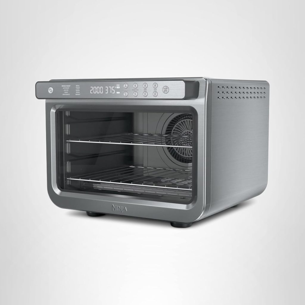 A stainless steel countertop convection oven with digital controls and two wire racks, featured for Amazon Prime Big Deal Days, shown on a plain light gray background.