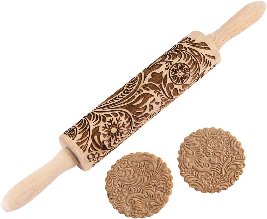 A wooden rolling pin with ornate floral engravings, perfect for imprinting matching decorative patterns on cookies or Air Dry Clay creations.