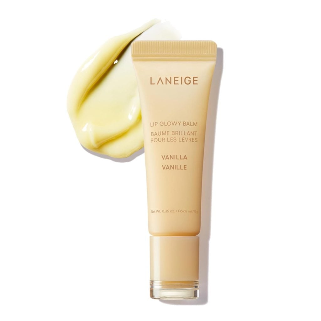 A tube of Laneige Lip Glowy Balm in Vanilla flavor is shown with a smear of the yellowish balm next to it on a white background—perfect for scoring during Amazon Prime Big Deal Days.