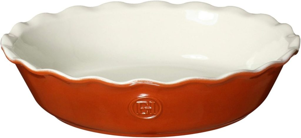 A round ceramic pie dish with a fluted edge, white interior, and vibrant Porto orange exterior.