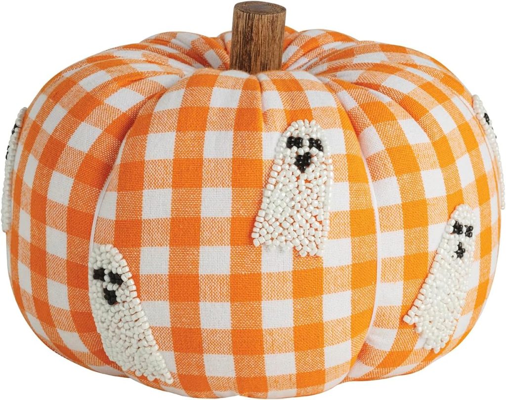 A fabric pumpkin with an orange and white checkered pattern, decorated with small beaded ghost designs and a brown stem.