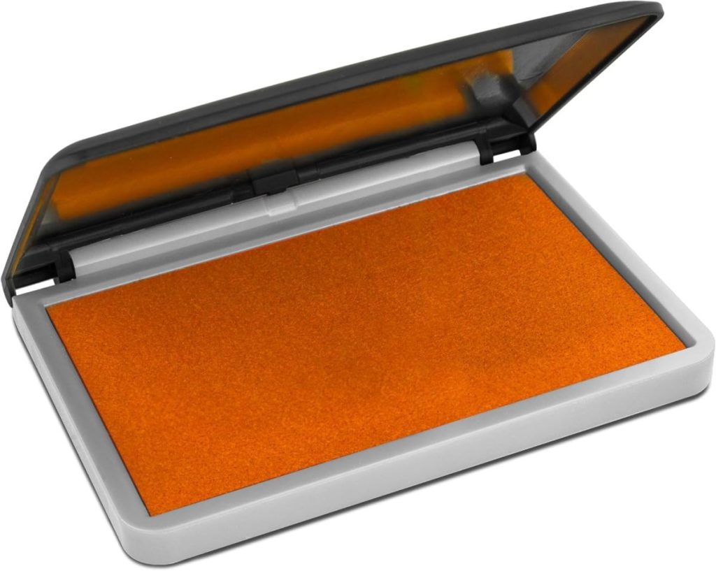 An open ink pad with an orange surface in a gray plastic case, the lid partially open—perfect for crafting projects inspired by "A Home to Share.