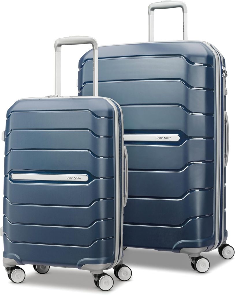 Two navy blue hard-shell suitcases with silver handles and four wheels each, shown standing upright side by side—perfect travel companions to grab during Amazon Prime Big Deal Days.