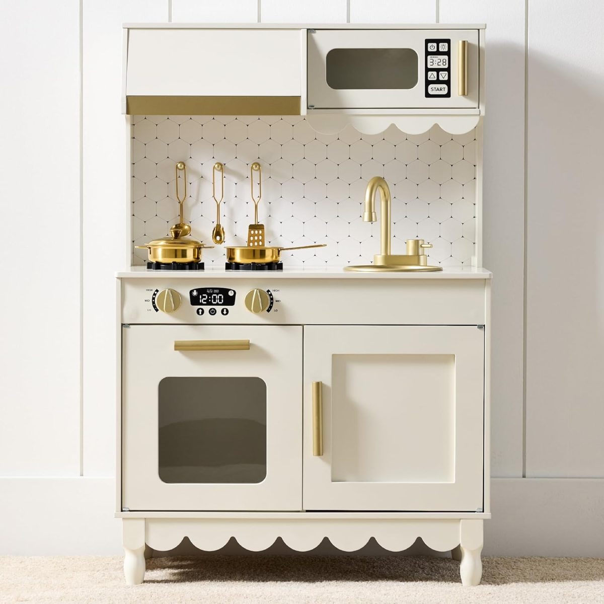 A white toy kitchen set with gold-colored utensils, faucet, stove, and microwave sits against a white wall with a patterned backsplash—perfect for imaginative play and now available during Amazon Prime Big Deal Days.