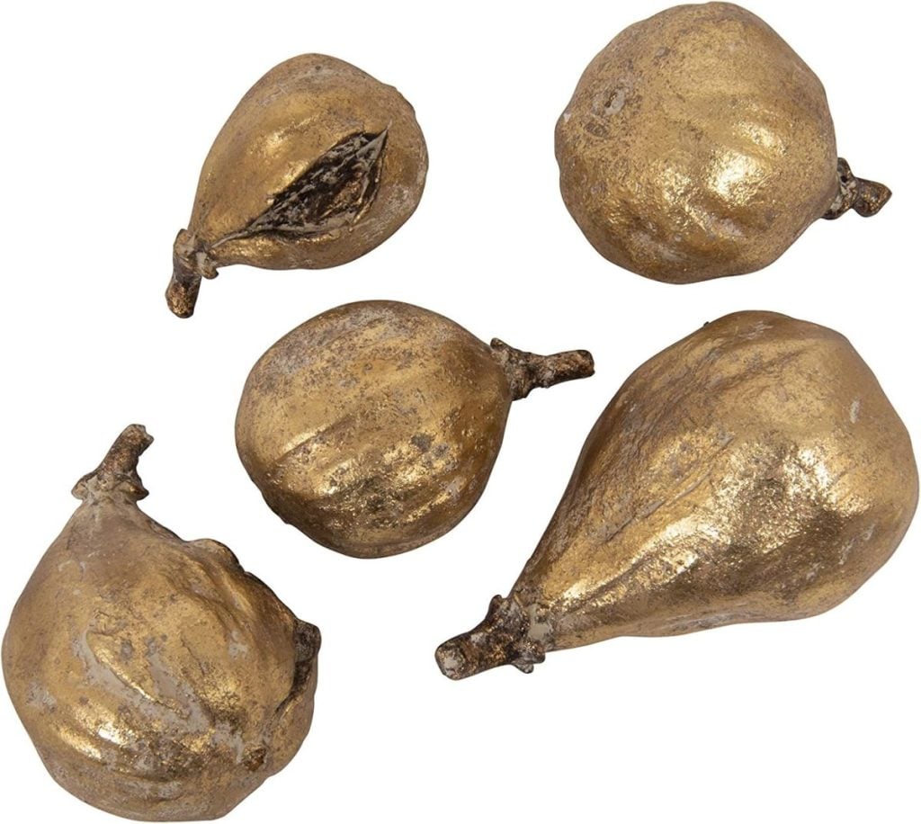 Five gold-painted artificial fruits, resembling figs and pears, arranged on a white background.