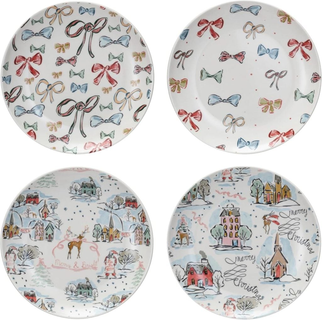 Four decorative plates crafted from air dry clay with holiday-themed designs: two feature festive bows, and two depict winter village scenes with houses, trees, and handwritten holiday messages.