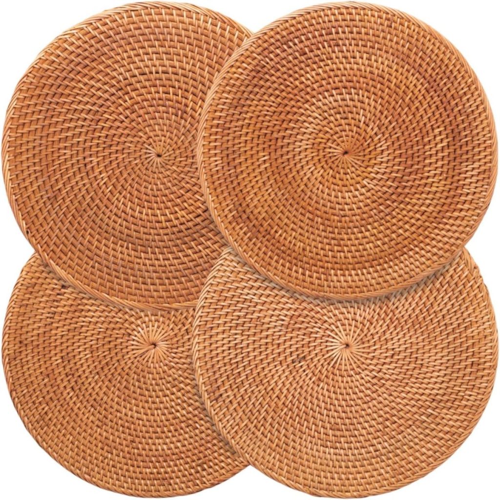 Four round, woven rattan placemats arranged in a slightly overlapping pattern on a white background.
