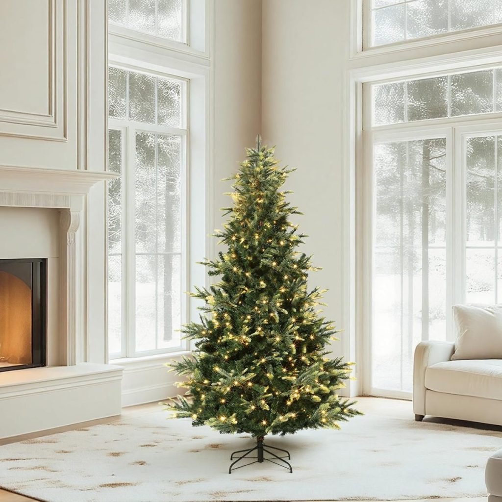 An undecorated Christmas tree with string lights stands in the corner of a bright, modern living room—ready to be styled for the holidays or Amazon Prime Big Deal Days—with large windows, a fireplace, and a white armchair.