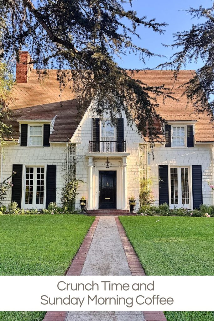 A two-story white house with black shutters, a steep roof, and a well-kept front lawn, seen on a clear day. Text at the bottom reads, "Crunch Time and Sunday Morning Coffee.