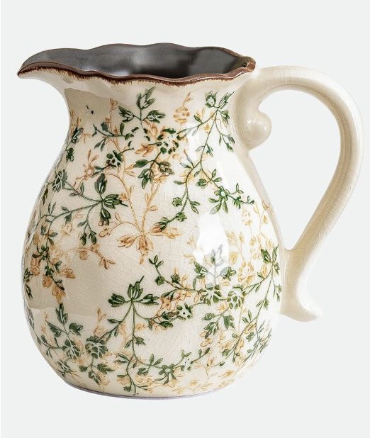 Cream-colored ceramic pitcher with a scalloped rim and handle, featuring a delicate floral pattern in green and yellow—perfect for adding charm to your pumpkin craft display.