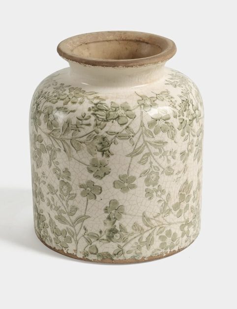 A ceramic vase with a wide mouth, decorated with a light green floral pattern and subtle painted pumpkins on a crackled cream background.