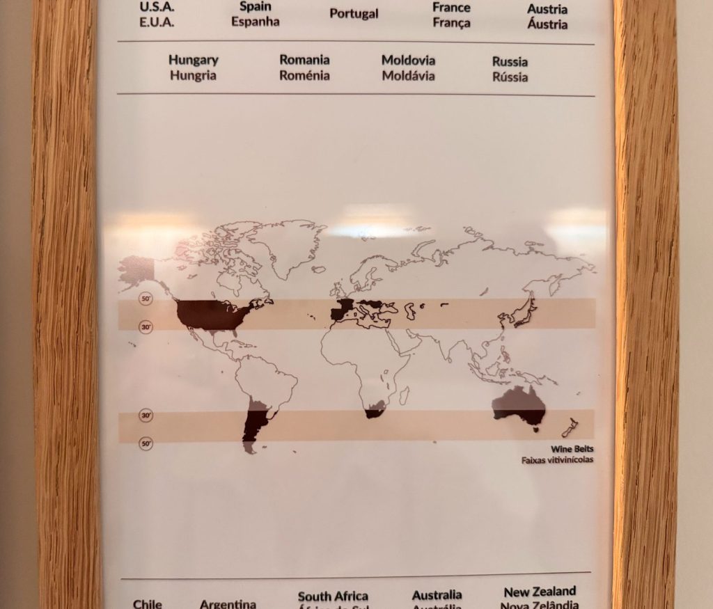 A framed map showing major wine-producing regions around the world, highlighted in dark areas between the latitudes of 30° and 50° in both hemispheres.