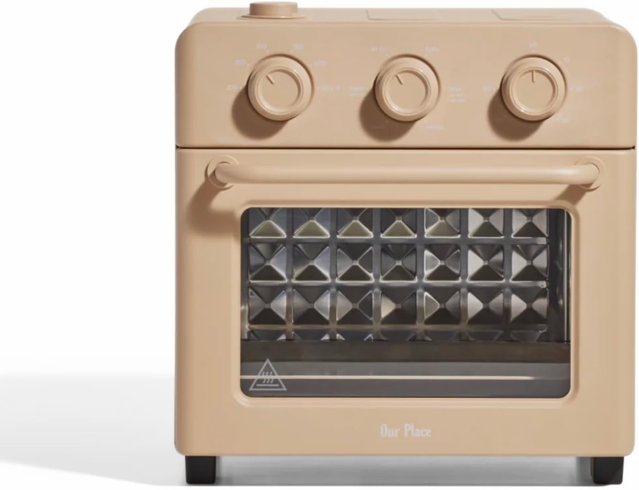 A beige countertop toaster oven with three control knobs on top, a clear glass front door, and a diamond-patterned interior—perfect for upgrading your kitchen during Amazon Prime Big Deal Days.