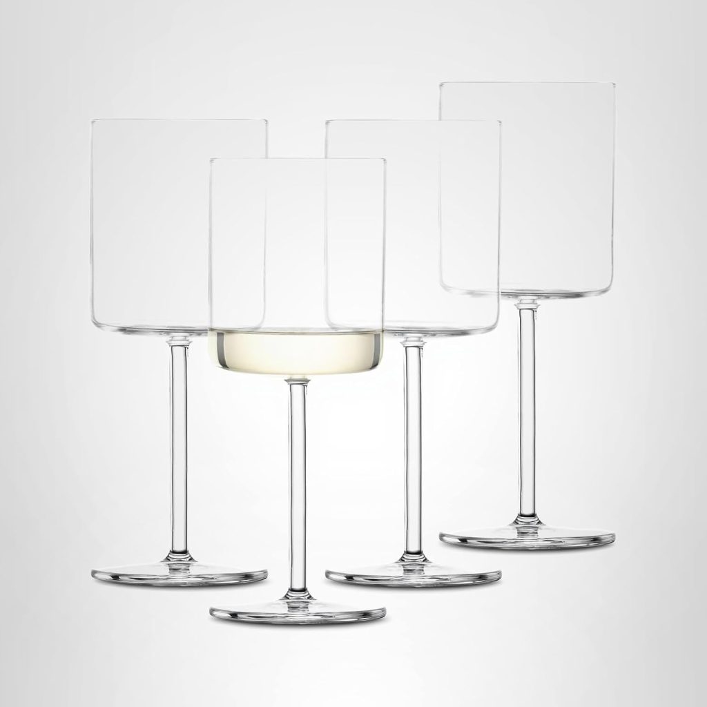 Four clear wine glasses with square rims are arranged together; one glass contains a small amount of white wine while the others are empty—perfect for your next toast during Amazon Prime Big Deal Days.