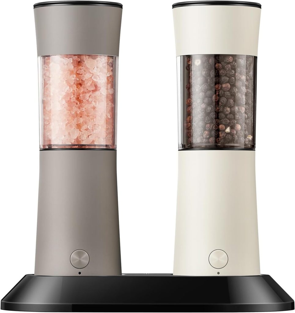 Two electric grinders with transparent containers—one filled with pink Himalayan salt and the other with black peppercorns—are placed on a black tray, perfect for seasoning dishes like Marry Me Chicken.
