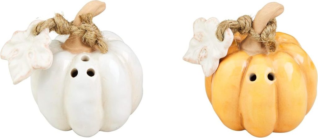 Two ceramic pumpkin-shaped shakers, one white and one orange, each with a stem, leaf, and two holes on top—perfect for adding a festive touch to your Marry Me Chicken dinner table.