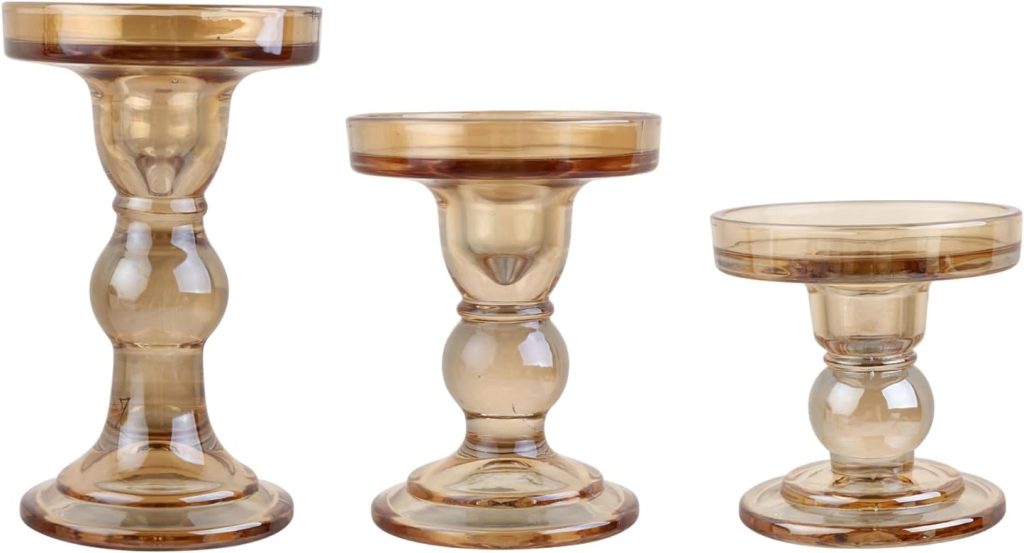 Three amber-colored glass candle holders of varying heights are displayed side by side against a white background, creating a warm accent that pairs beautifully with Burlap Christmas Trees for a cozy holiday display.
