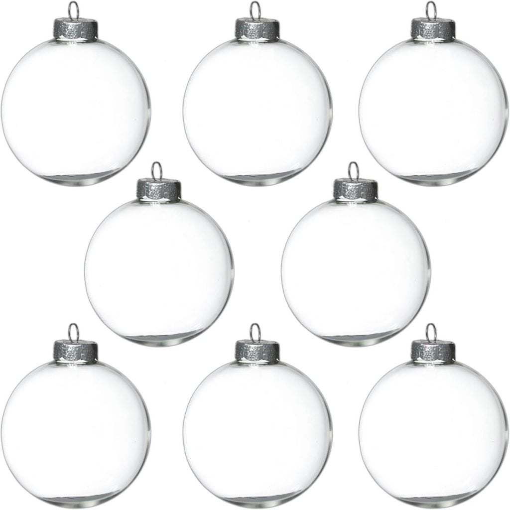 Eight glass ornaments with silver caps are arranged in two neat rows on a plain white background.