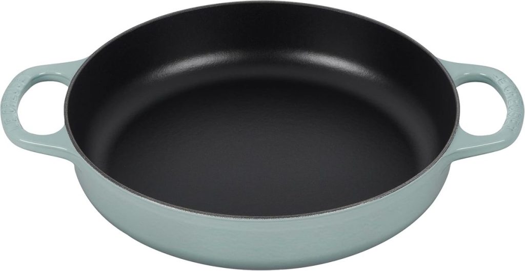 A round, light blue cast iron pan with two handles, perfect for dishes like Marry Me Chicken, is shown empty on a white background.
