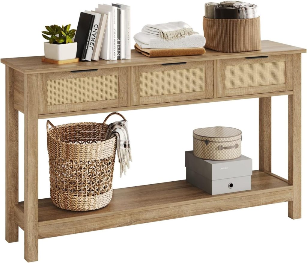 A wooden console table with three woven-front drawers, books, baskets, a potted plant, and decorative items—perfect for styling your space or finding great on Amazon Prime Big Deal Days.