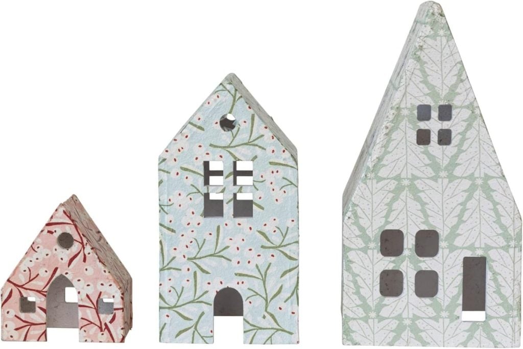Three decorative, house-shaped ornaments with leaf and berry patterns in red, blue, and green, arranged in order of increasing size from left to right.