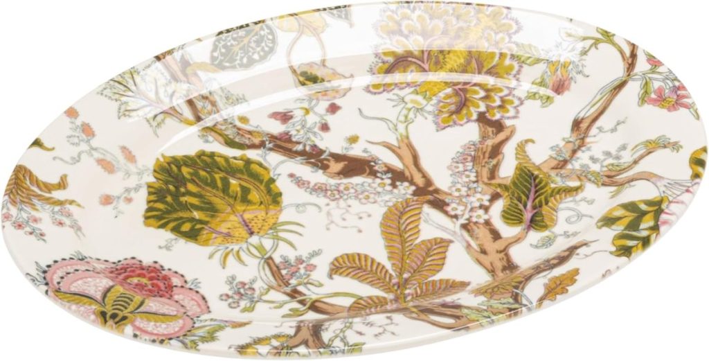 An oval ceramic plate with a cream background featuring an intricate floral and foliage pattern in shades of green, pink, yellow, and brown—perfect for serving dishes like Marry Me Chicken at your next gathering.