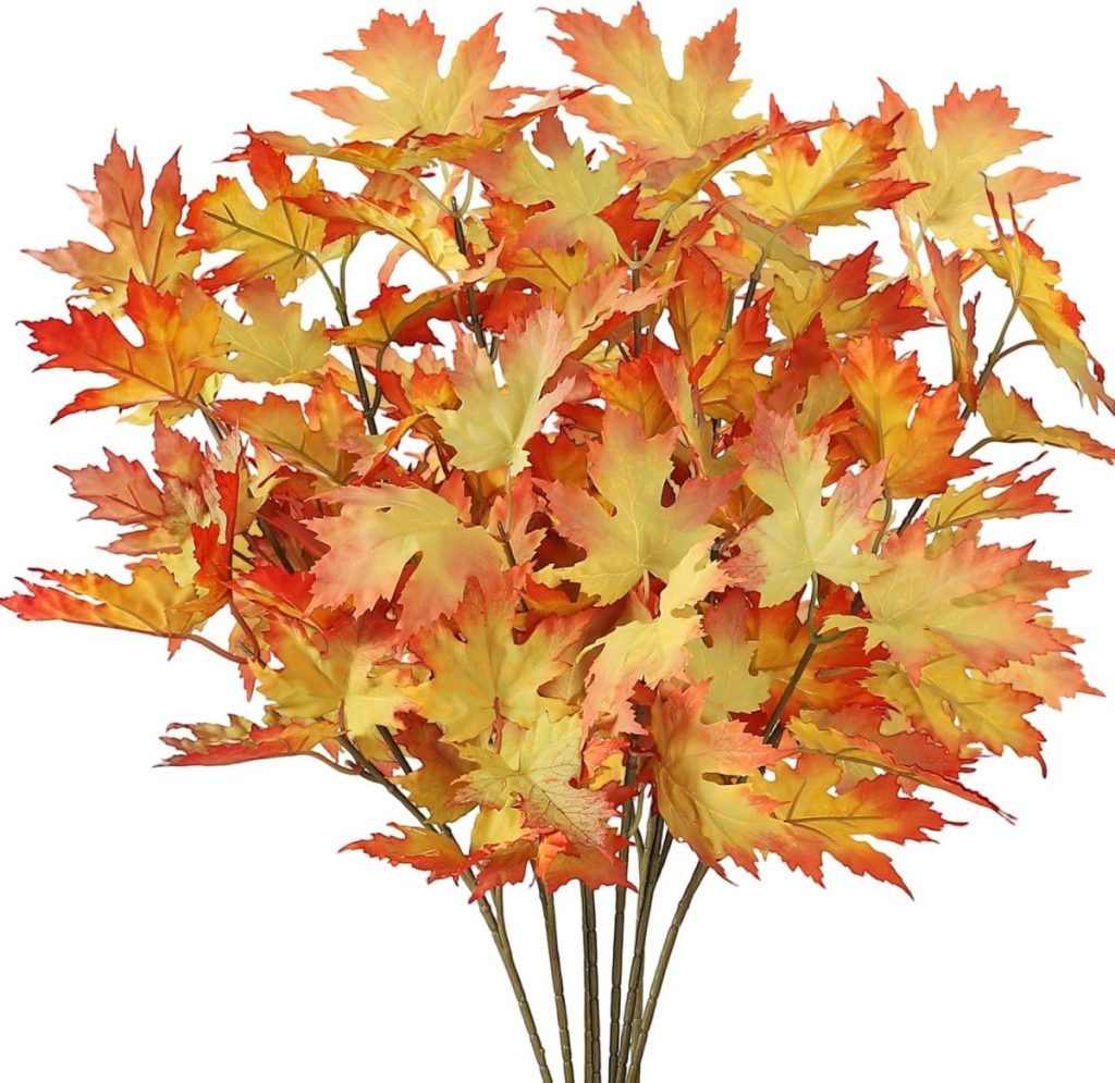 A bunch of artificial branches with yellow, orange, and red maple leaves arranged together against a white background, evoking the cozy warmth of autumn and the aroma of pumpkin pie.