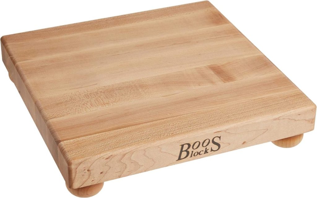 Square wooden cutting board with rounded feet, engraved with "Boos Block" on the side, displayed on a white background.