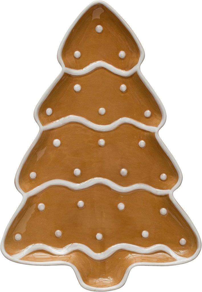 A ceramic plate shaped like a Christmas tree, brown in color with white dots and wavy white lines as decoration.